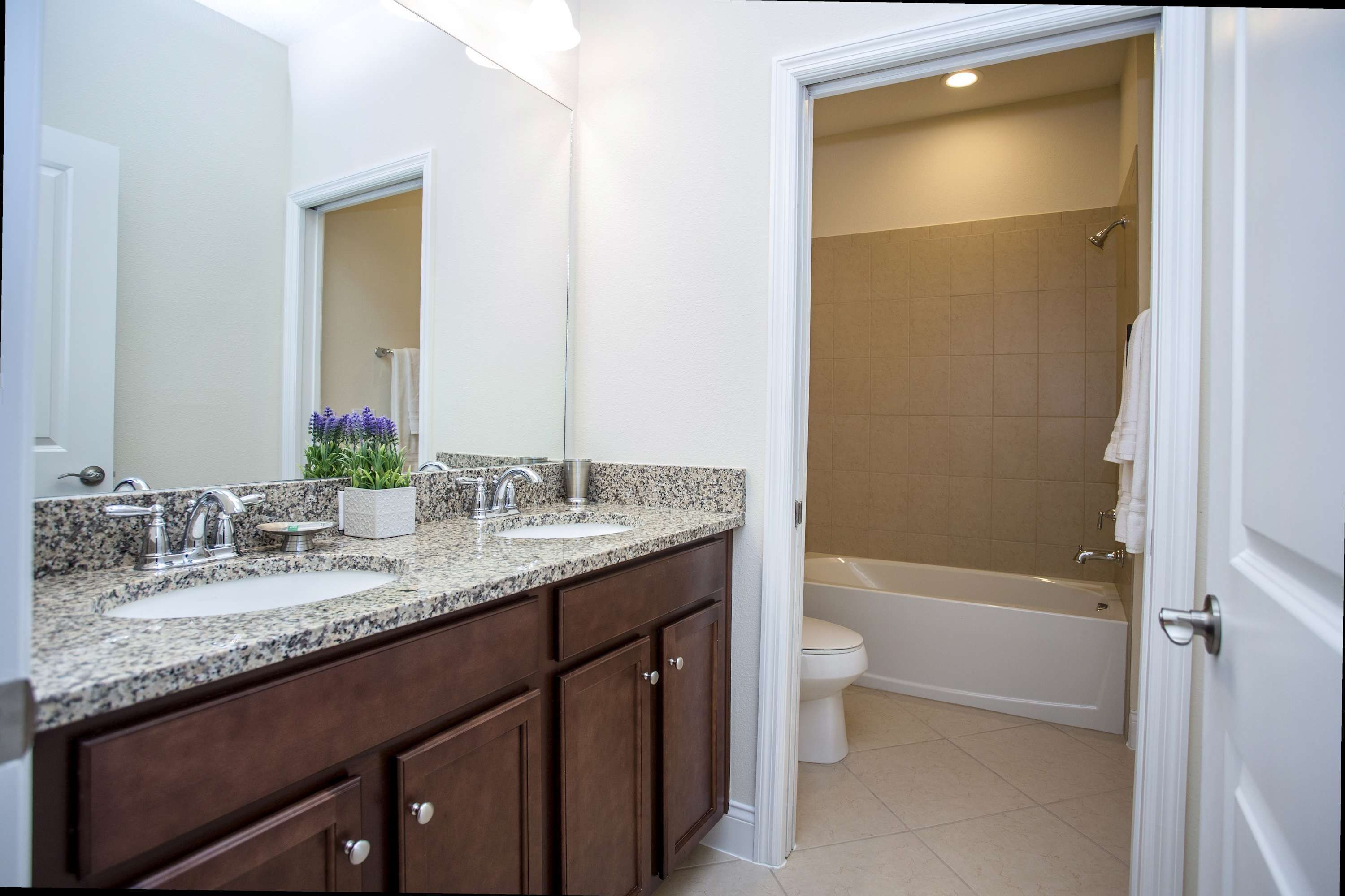 A bathroom with two sinks, a bathtub, and a shower.
