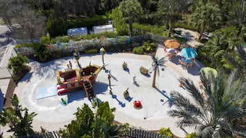 Ein Wasserpark mit Piratenschiff-Spielbereich, Palmen und einem umzäunten Bereich.