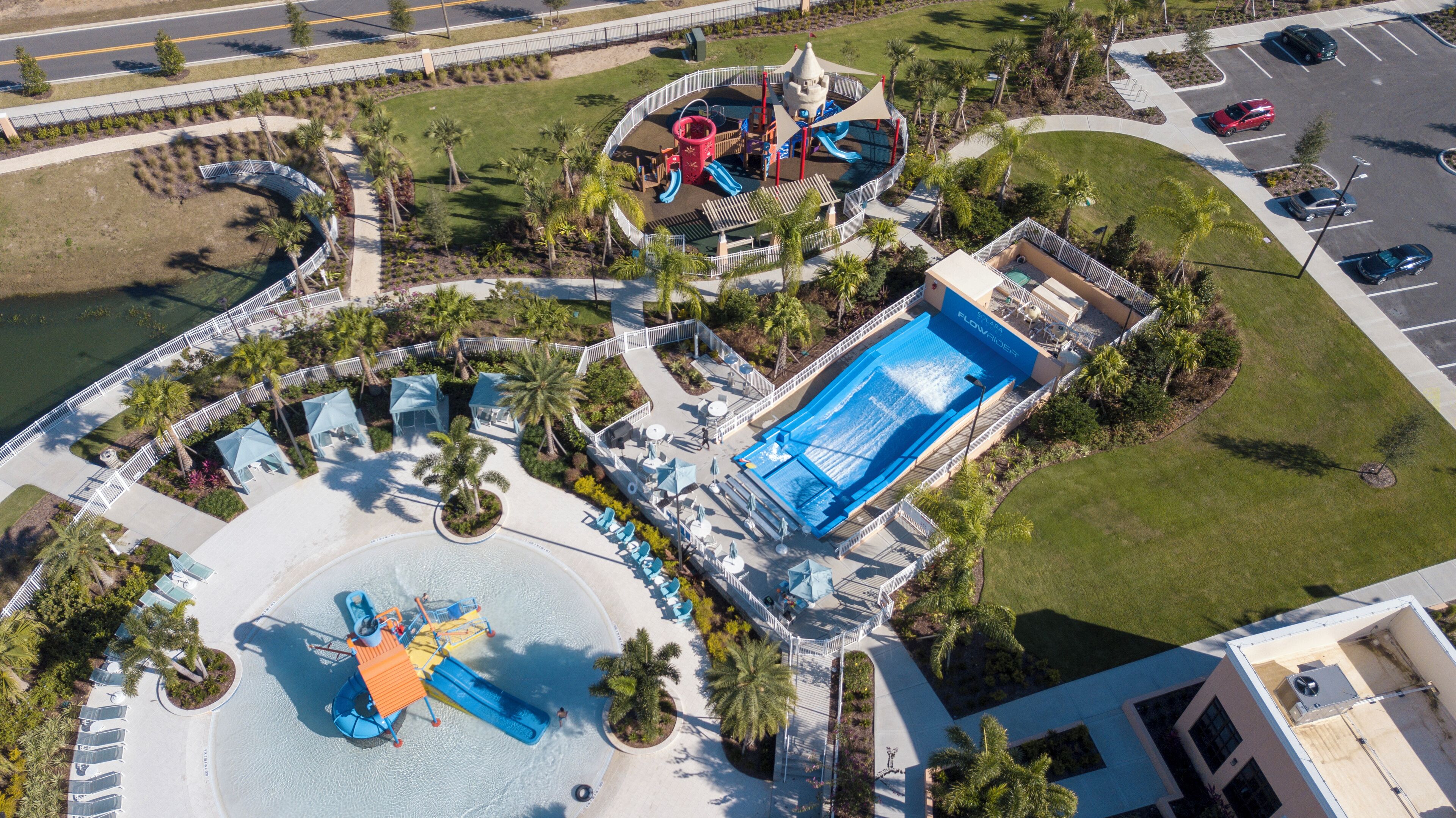 Vista aerea di un resort con una grande piscina, scivoli d'acqua e un'area giochi.