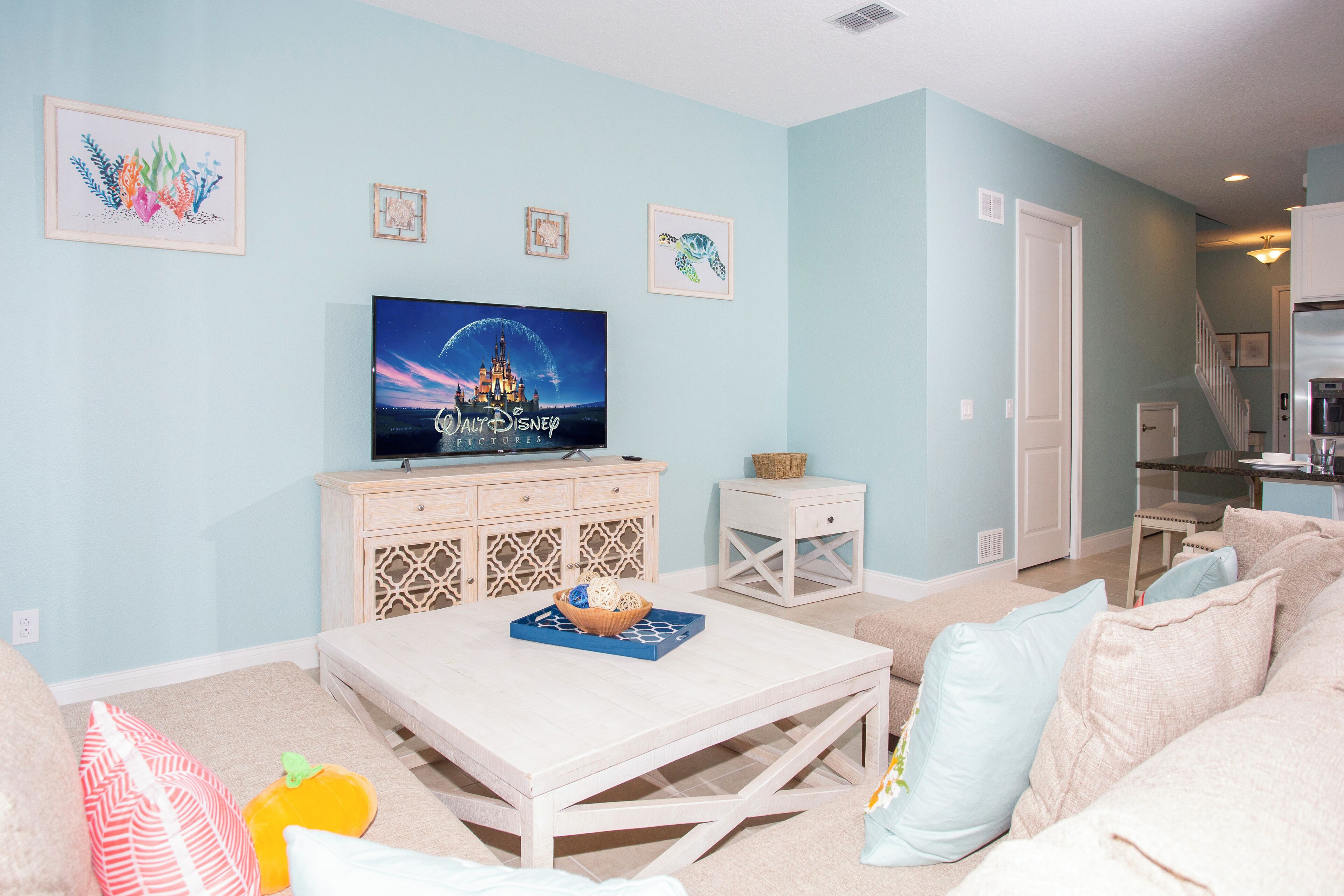A living room with a TV, a dining table, and a sofa.