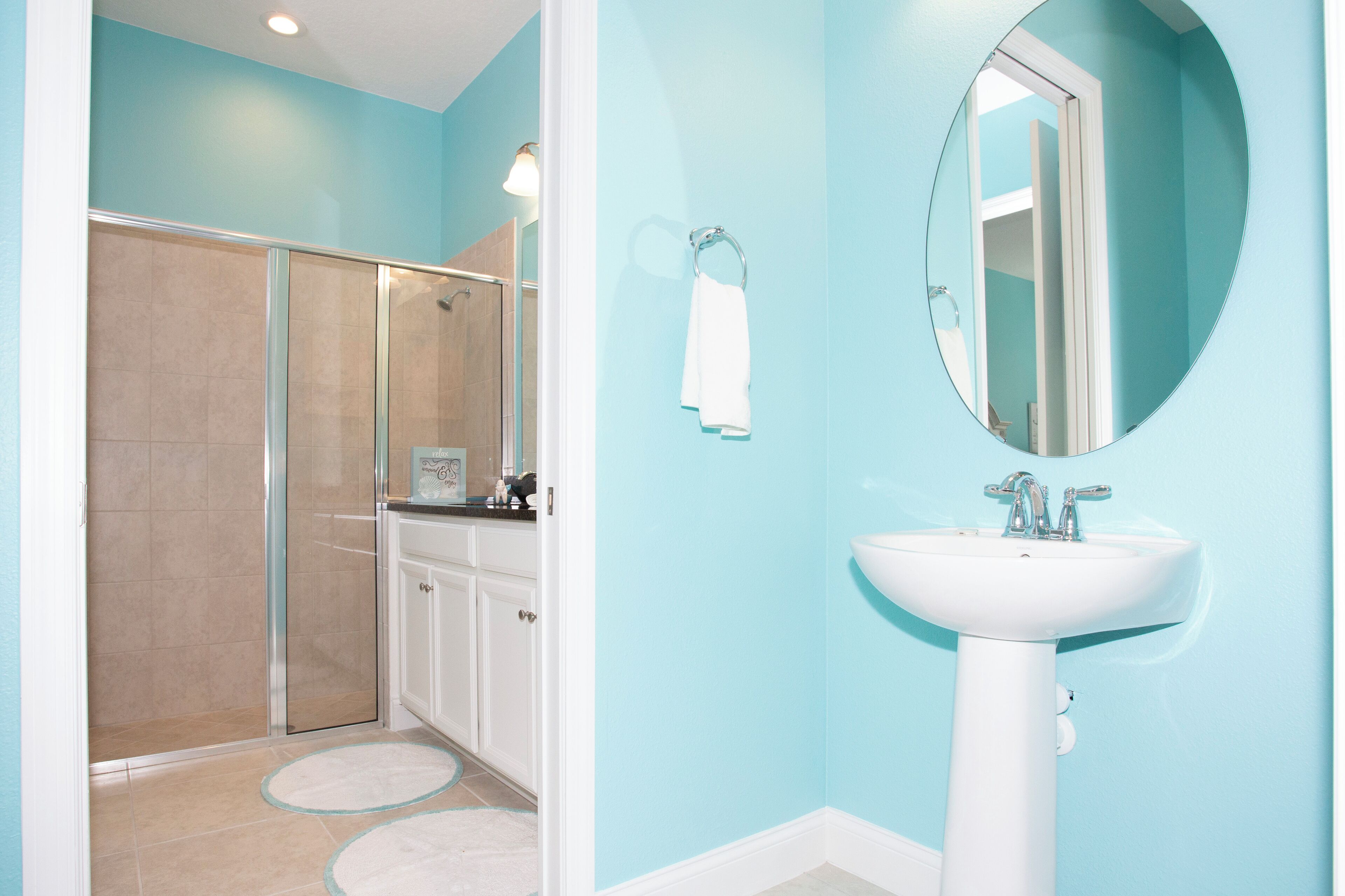 A bathroom with a shower, a sink, and a mirror.