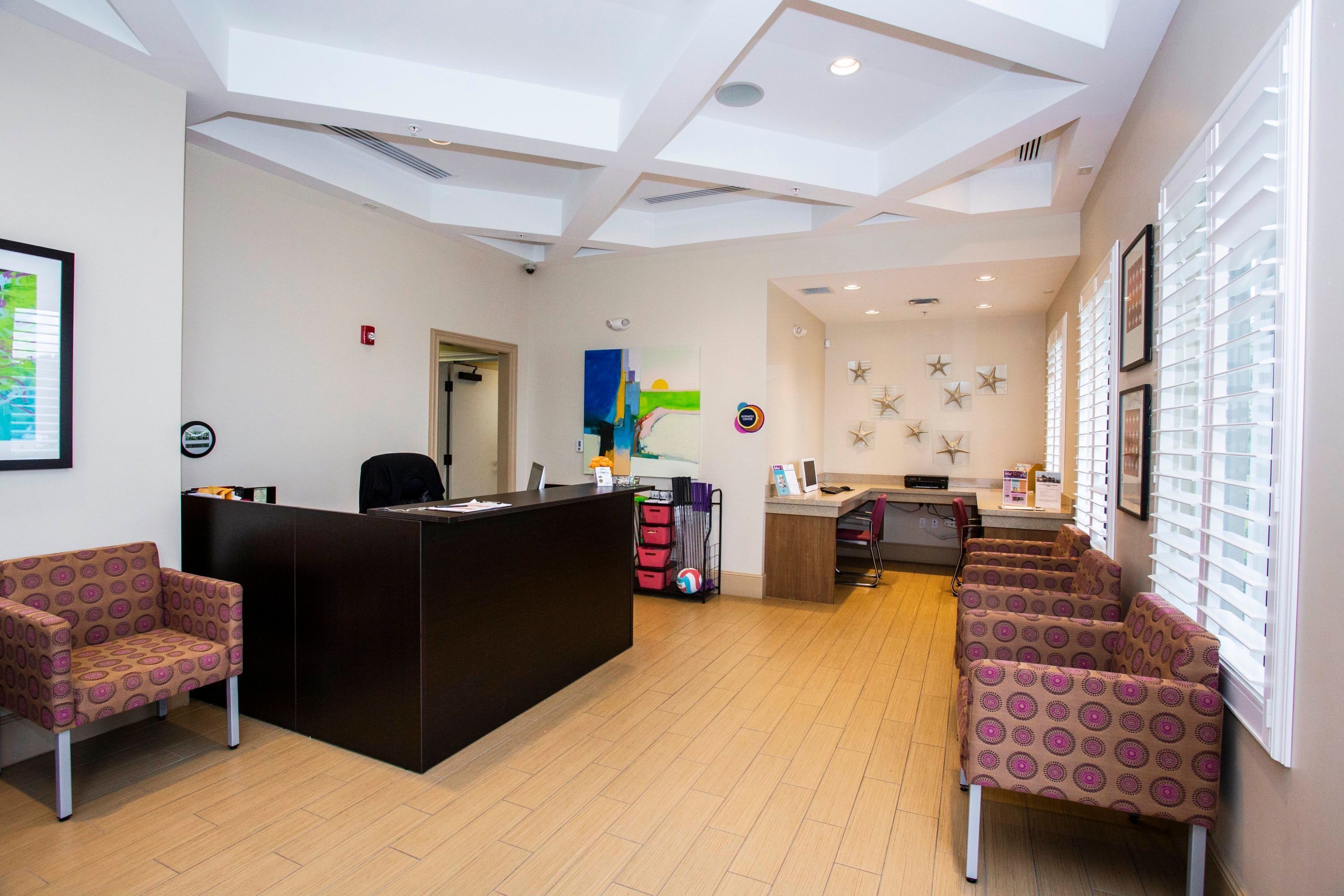 A reception area with a desk, chairs, a wall with star decorations, and a ceiling with skylights.