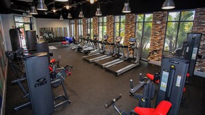A gym with treadmills, weight machines, and exercise equipment. - Festival Resort 5 Bd Home w Screened Pool Close to Disney 174 (Davenport)