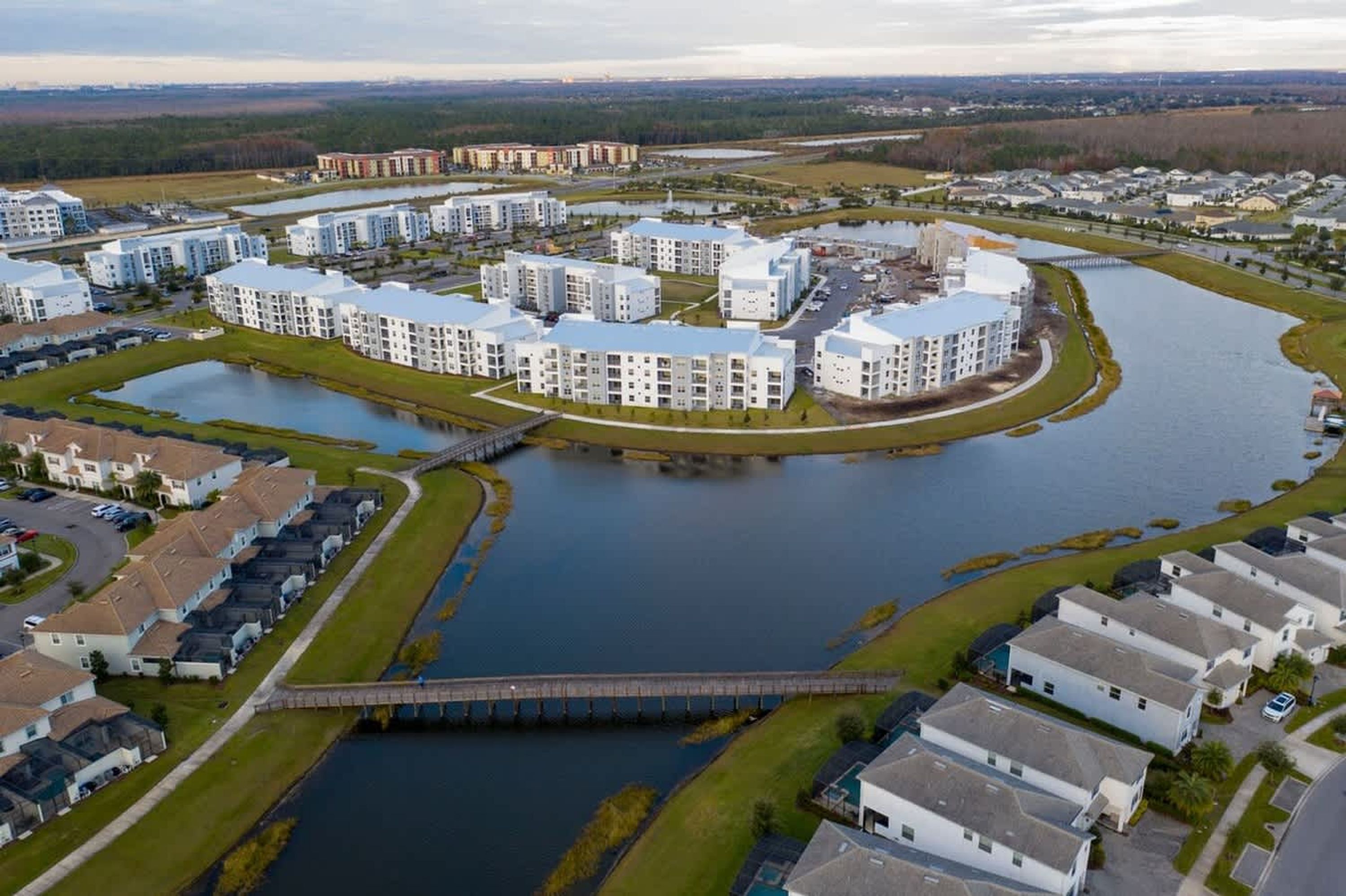 Un quartiere residenziale con palazzi moderni, un fiume e un ponte.