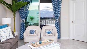A living room with two armchairs, a sofa, a large plant, and a tray of decorative items. - Luxurious 3Bd 8 Guests Storey Lake Resort Close to Disney 201 3131 (Kissimmee)