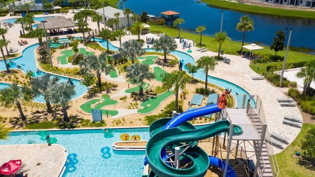 A water park with a large pool, slides, and a golf course. - Luxurious 3Bd 8 Guests Storey Lake Resort Close to Disney 201 3131 (Kissimmee)