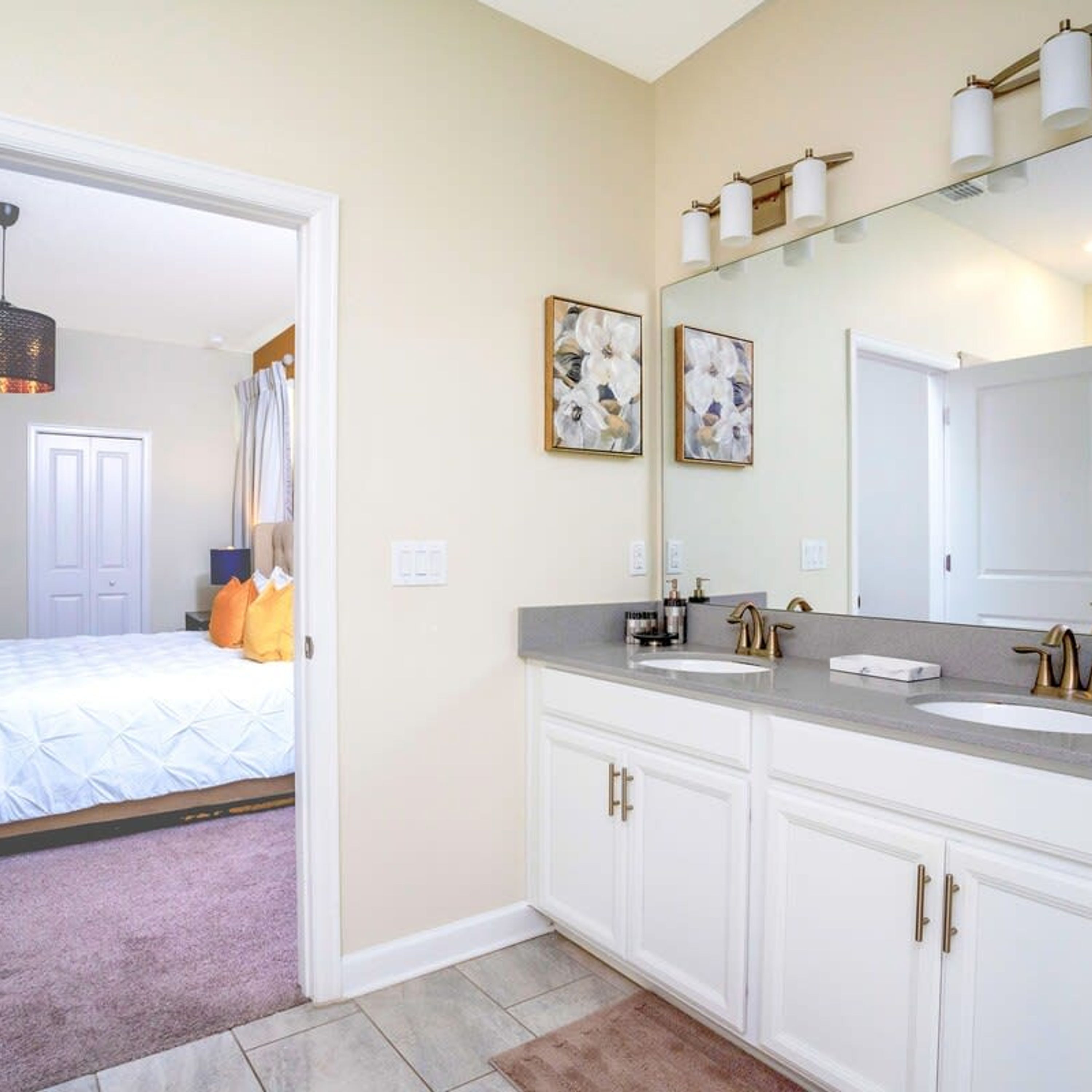 A modern bathroom with a large mirror, two sinks, and a walk-in shower.