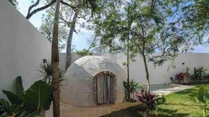A white building with a dome-shaped structure, surrounded by greenery and a pathway. - Luxurious Apartment With Jacuzzi Privado (Tulum)