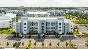 A multi-story residential building with a parking lot in front.