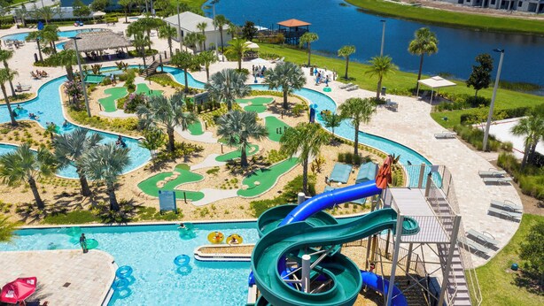 A water park with a large pool, multiple slides, and a golf course.