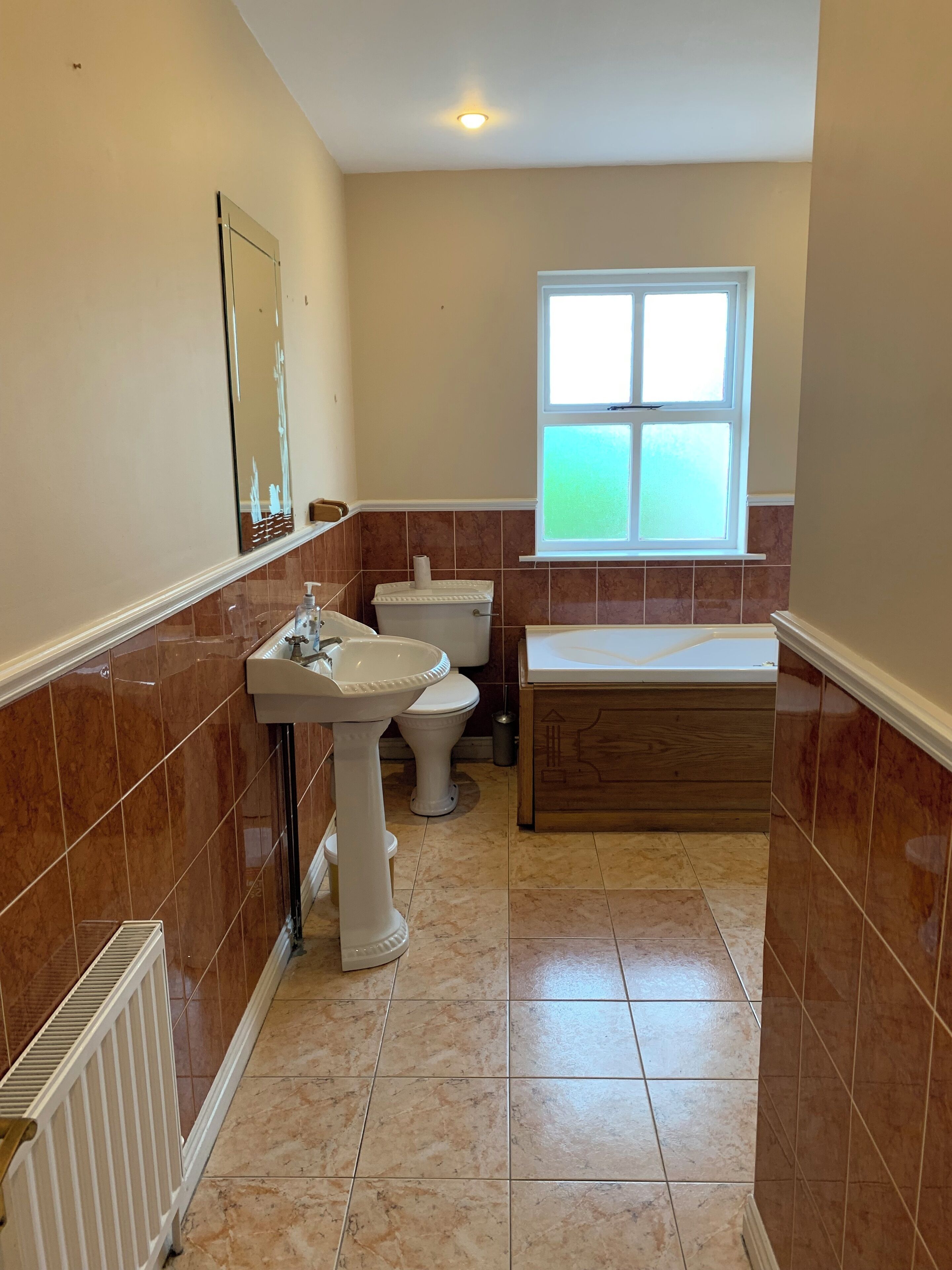A bathroom with a pedestal sink, toilet, and bathtub.