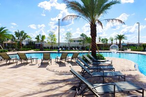 A pool area with sun loungers and palm trees. - Four Bedroom Storey Lake Resort Close to Disney w Pool 3063 (Kissimmee)