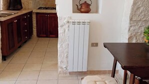 Una cocina con estufa, armarios y radiador.