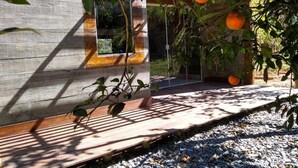 A modern building with a concrete facade and a wooden deck. - Farmless Home (Tiradentes)