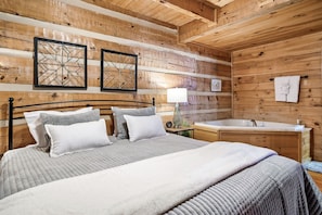 Cozy bedroom with a neatly made bed, modern mirror, and sink.