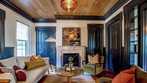 Un salon chaleureux avec une cheminée, un canapé, une table basse et un fauteuil.