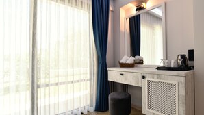 A modern bathroom with a vanity, a mirror, and a window with sheer curtains. - Tahir Ağa Hotel Datça (Datça)