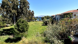A house with a red-tiled roof, surrounded by lush greenery and a clear blue sky. - Tahir Ağa Hotel Datça (Datça)