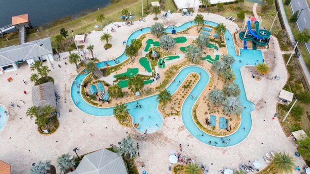 An aerial view of a water park with multiple pools, slides, and a basketball court. - Gorgeous 5Bd Single Family w Pool Storey Lake 2767o (Kissimmee)
