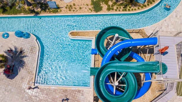 A swimming pool with a water slide and a separate pool area. - Gorgeous 5 Bd Home Close to Disney Storey Lake Resort 2734 (Kissimmee)