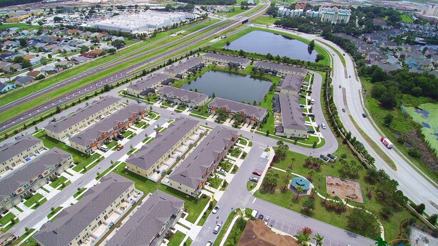 Luchtbeeld van een woongebied met meerdere appartementencomplexen, wegen en een groot wateroppervlak.