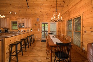 Cozy cabin-style interior with a long dining table and comfortable seating for meals.