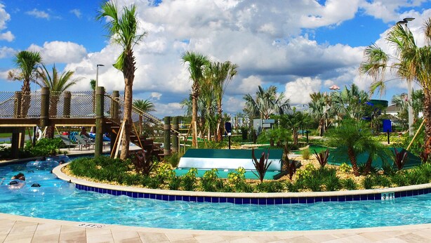 A swimming pool with palm trees, a covered seating area, and a fenced playground. - Storey Lake 4 Bedrooms Near Disney Orlando FL 3079 (Kissimmee)