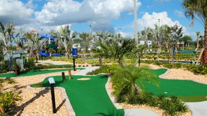 A golf course with a putting green, palm trees, and a water slide. - Storey Lake 4 Bedrooms Near Disney Orlando FL 3079 (Kissimmee)