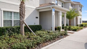 A two-story residential building with a beige exterior, a visible address number 3079, and a wheelchair accessibility sign. - Storey Lake 4 Bedrooms Near Disney Orlando FL 3079 (Kissimmee)
