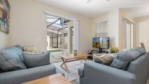 A modern living room with grey sofas, a wooden coffee table, and a TV. - Storey Lake 4 Bedrooms Near Disney Orlando FL 3079 (Kissimmee)