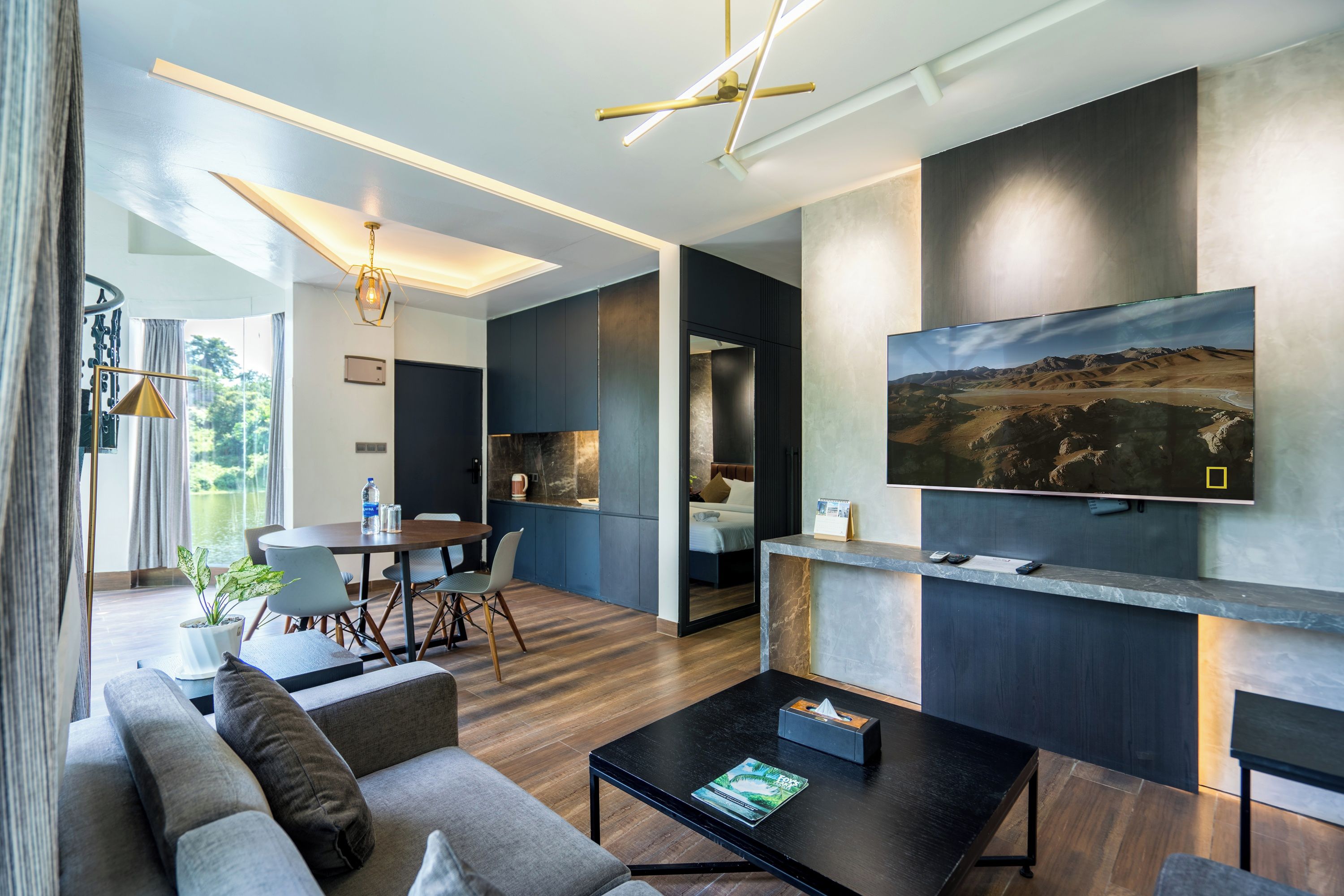 A modern living room with a sofa, coffee table, and a TV mounted on the wall.