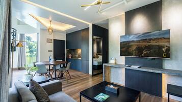 A modern living room with a sofa, coffee table, and a TV mounted on the wall.