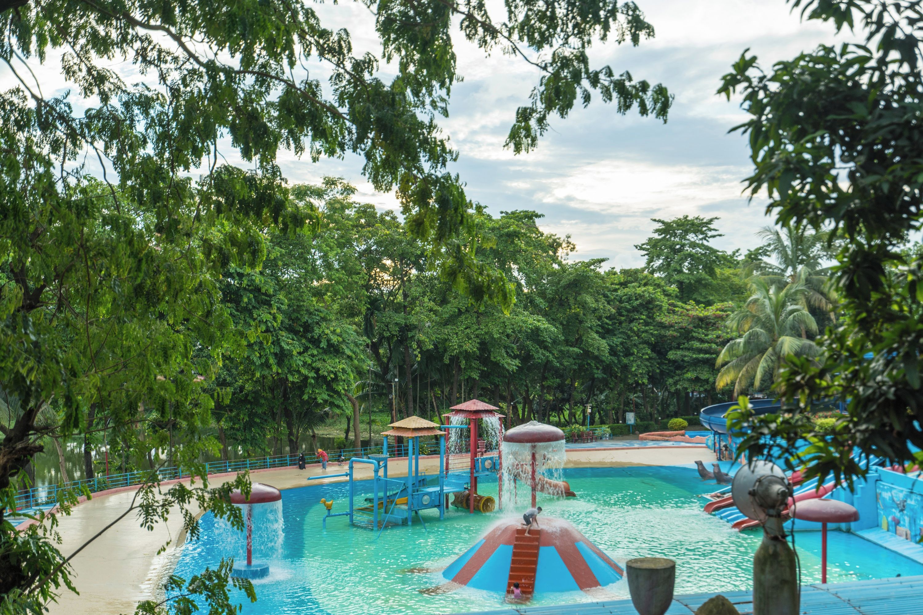 Parque acuático con piscina central, toboganes y zona de juegos de agua.