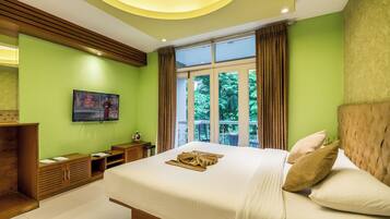 Habitación de hotel moderna con una cama grande, un televisor montado en la pared y vistas a zonas verdes por la ventana.