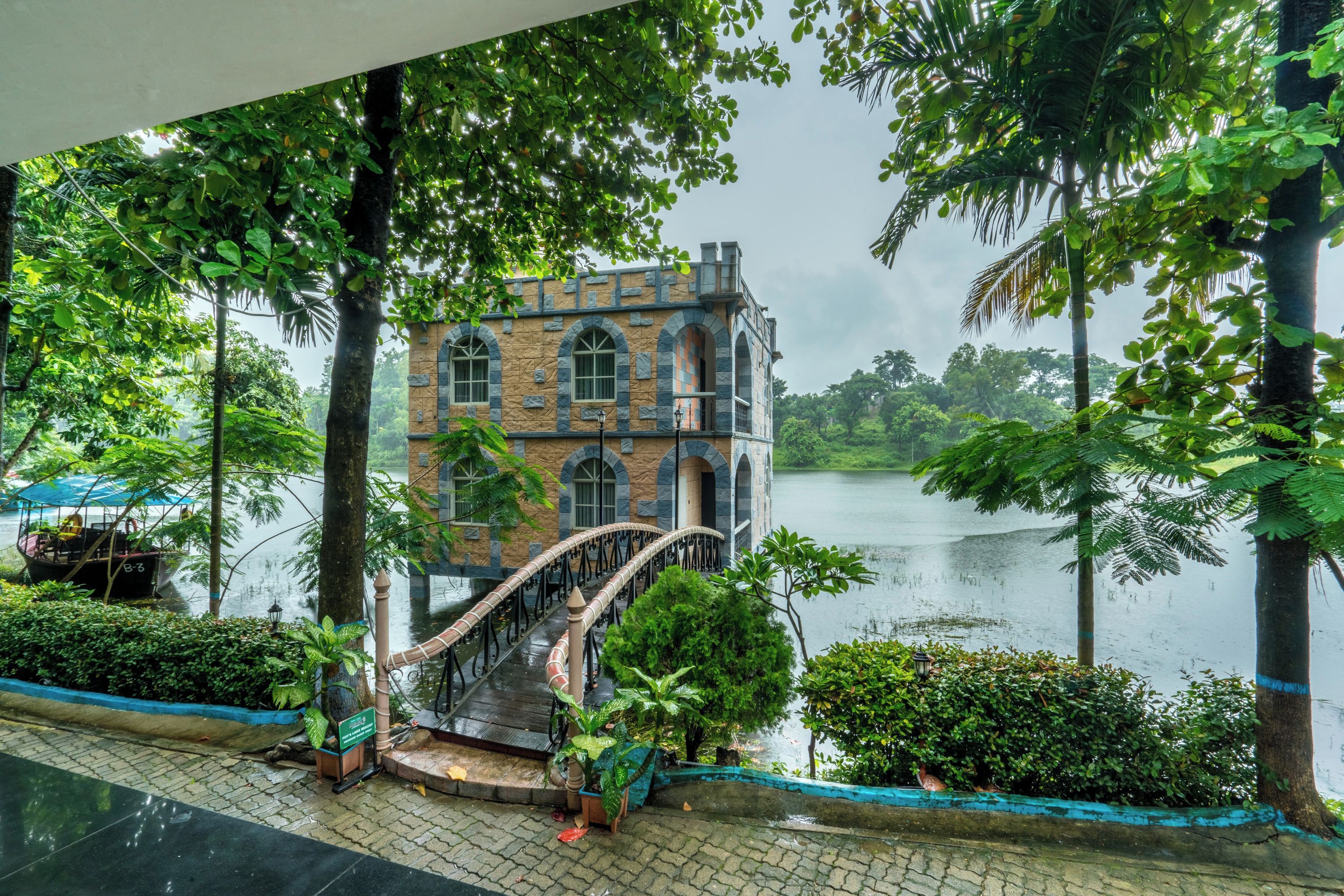 A stone building with arched windows and a bridge leading to a body of water.