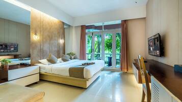 A modern hotel room with a bed, desk, and TV.