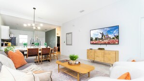 Una sala de estar moderna con un sofá, una mesa de centro y un televisor montado en la pared.