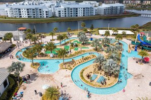 Un complexe hôtelier doté d’une grande piscine, de palmiers et offrant une vue sur une étendue d’eau.
