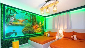 Een slaapkamer met een groot muurschildering, twee bedden en een nachtkastje met een lamp.