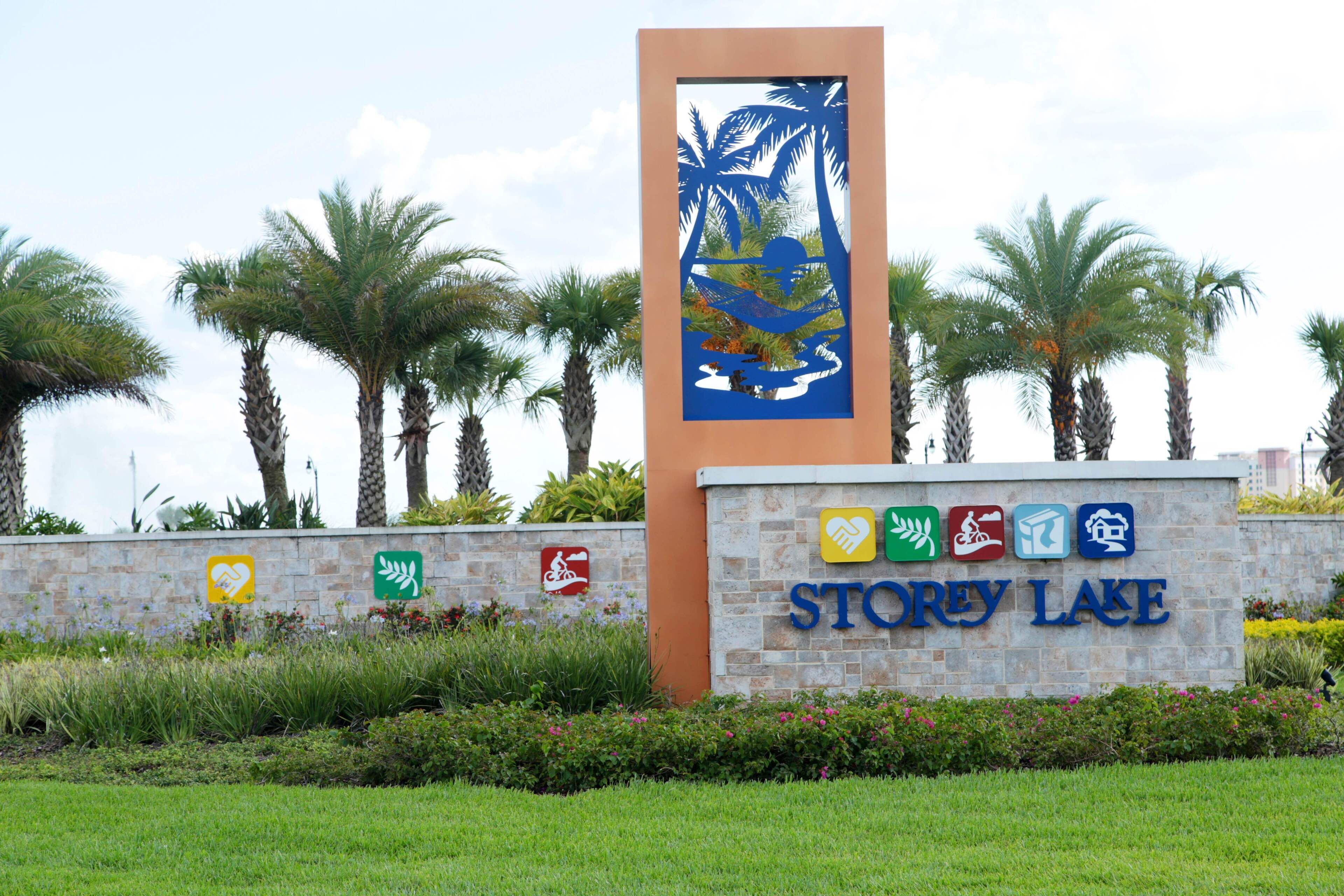 A sign for Storey Lake with palm trees and a beach scene.