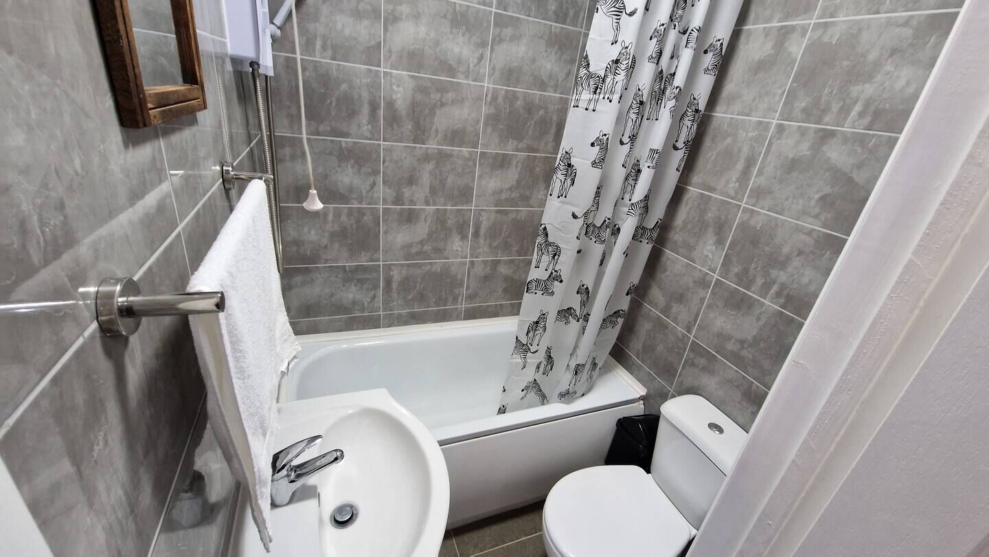 Une petite salle de bain avec une baignoire, un lavabo et des toilettes.