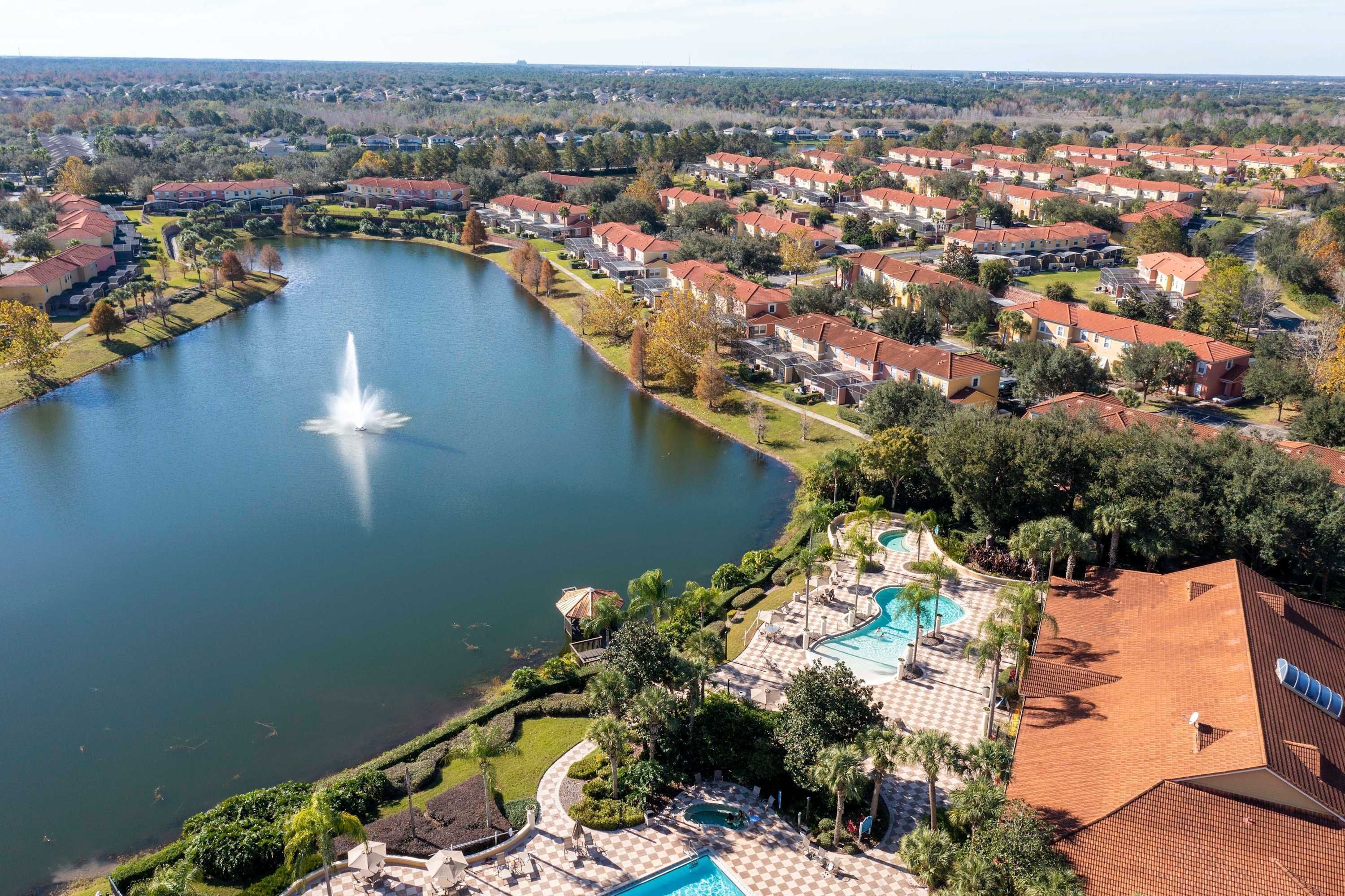A residential area with a lake, a fountain, and a swimming pool.