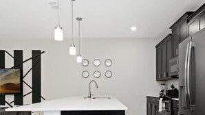 A modern kitchen with a central island, stainless steel appliances, and pendant lighting. - Four Bedrooms w Pool Townhome 4841 (Kissimmee)