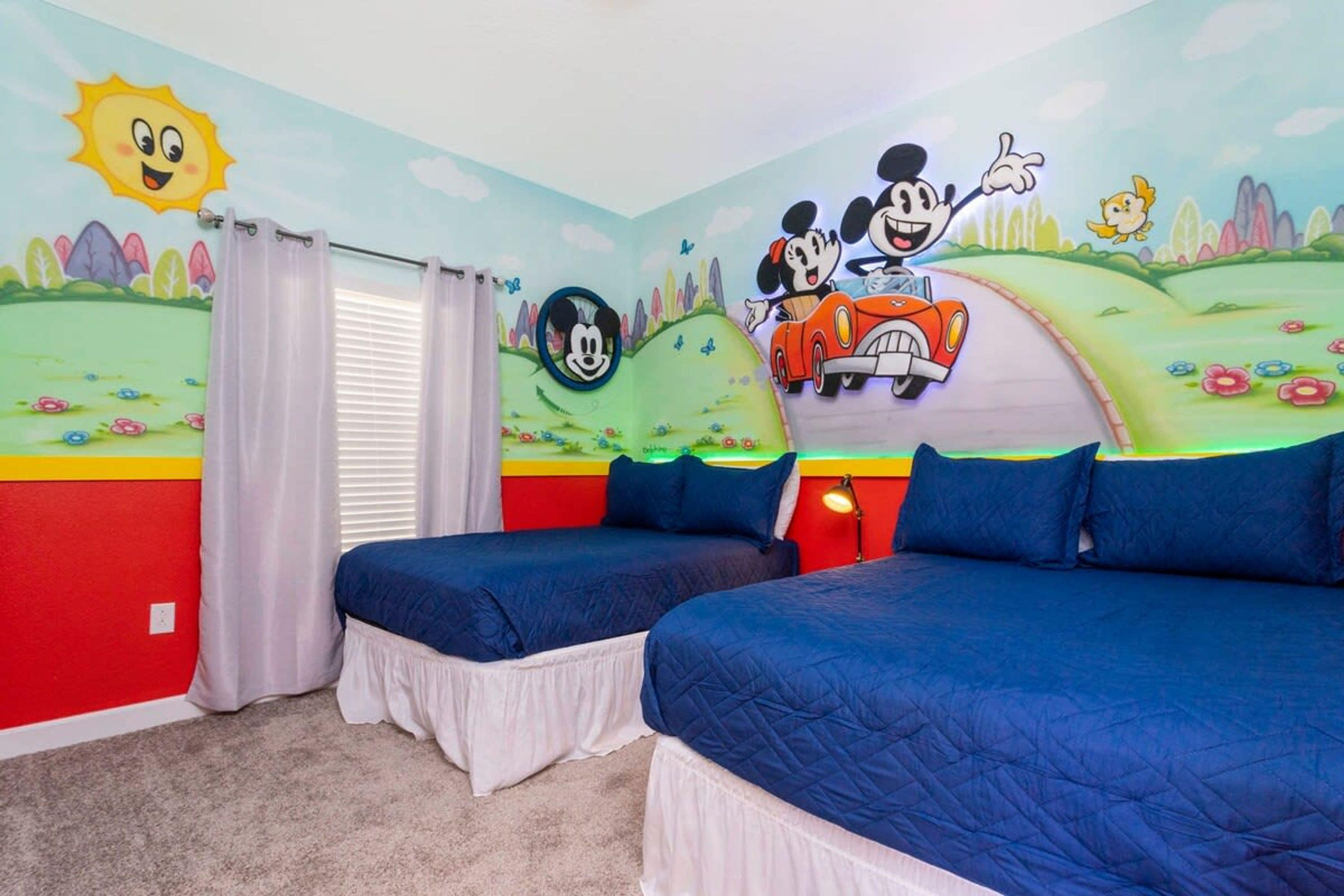 Une chambre avec deux lits, des murs aux couleurs vives et des personnages de dessins animés.