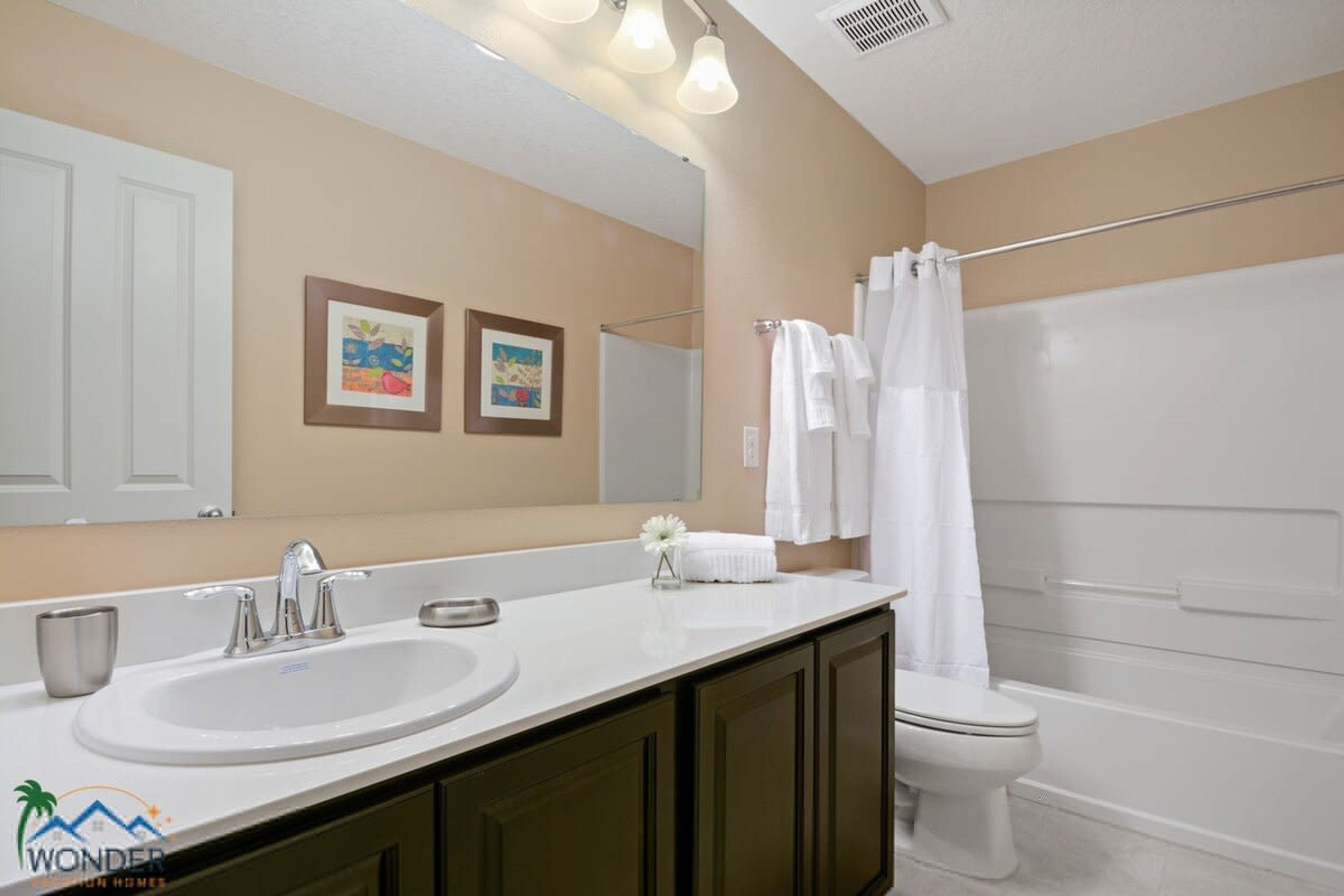 A bathroom with a sink, mirror, toilet, and shower.