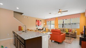 Eine moderne Küche mit Granit Arbeitsplatten, einem eingebauten Backofen und einer Essecke mit einer Couch und einem Couchtisch.