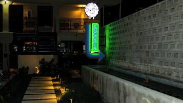 A hotel entrance with a neon sign reading "ANGORA" and a directional arrow.