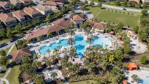 An aerial view of a resort with a large central pool, multiple villas, and a well-maintained landscape. - Gorgeous 5 Bd w Pool Jacuzzi Close to Disney 6071 (Davenport)
