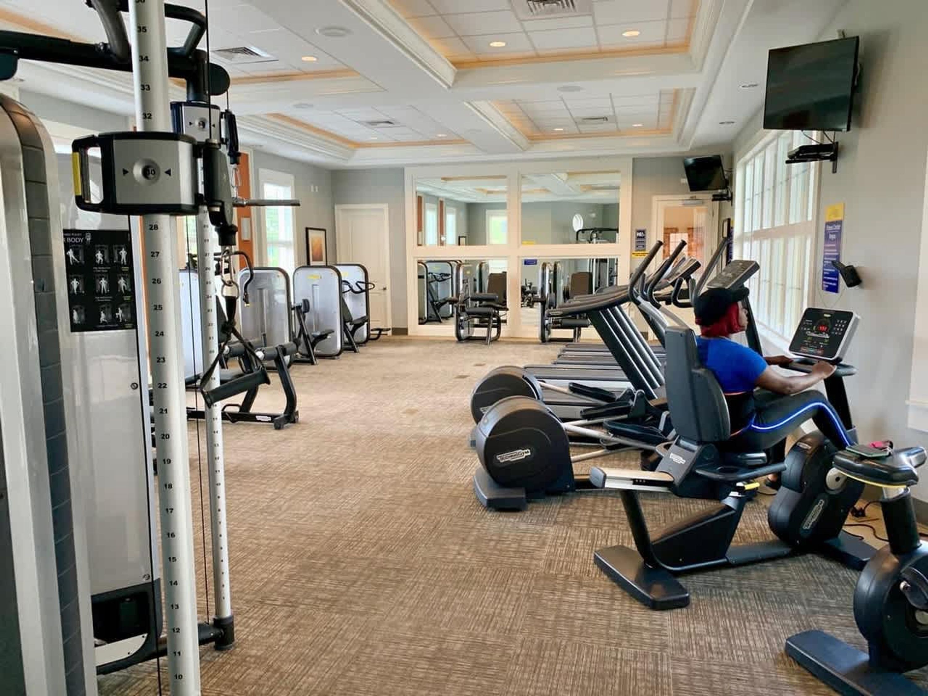 Une salle de sport équipée de machines de cardio, de machines de musculation et d’un écran de télévision.