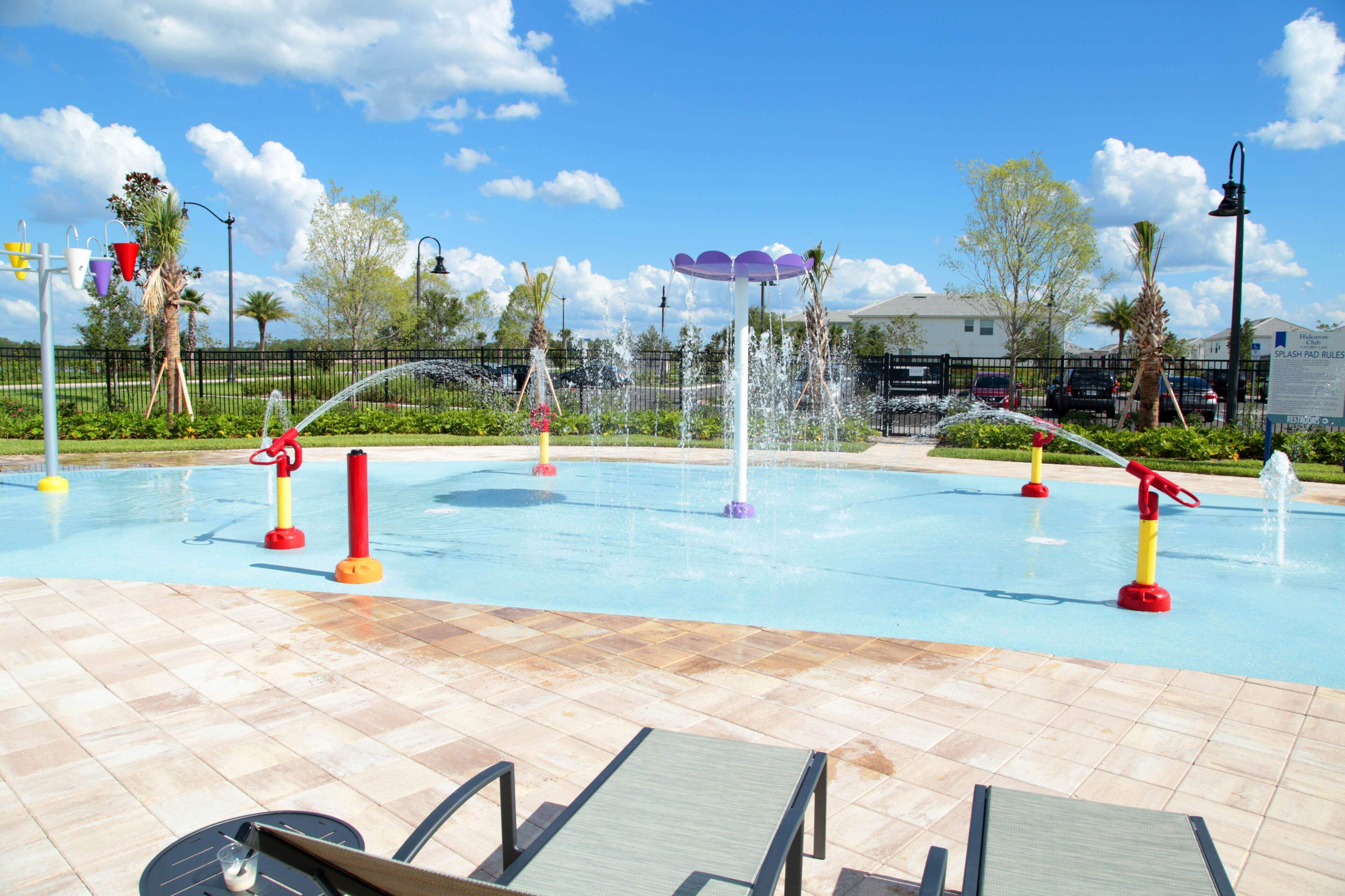 A swimming pool with multiple water jets and a tiled deck area.